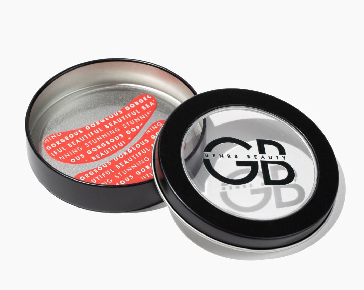 black tin container with clear top and logo with red silicone eye patches that say 'beautiful, stunning, gorgeous'.